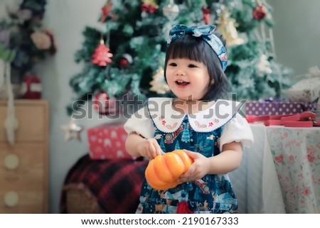 Asian baby in Christmas party celebration festival. Cute 1 year happy baby doing activity, smiling at home with family as Christmas concept.