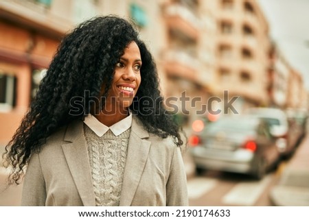 Middle age african american businesswoman smiling happy standing at the city.