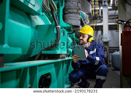 Power plant engineer controlling gas generator inside factory. Electricity production. Royalty-Free Stock Photo #2190178231