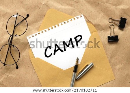 CAMP, craft background. text on white paper on an envelope
