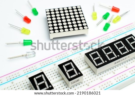 Breadboard close-up, seven segment indicators and color led lamp. LED matrix and colorful diodes. Concept of a DIY arduino project. Background picture.