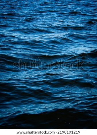 Close-up minimal image of waves in dark blue lake water.