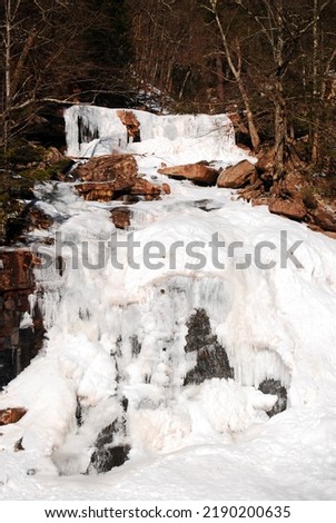 A frozen waterfall cascades in winter