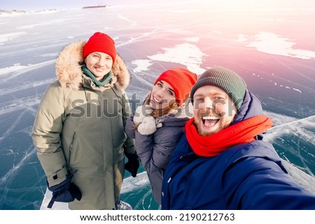 Happy tourists company friends are smiling background winter frozen ice of Lake Baikal.
