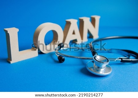 Photo from left front on blue background with stethoscope in front of loan letters