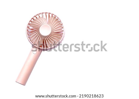 Mini electric pink fan with handle, isolated on white background. Concept : Portable electrical equipment that very useful when hot weather.                                       Royalty-Free Stock Photo #2190218623