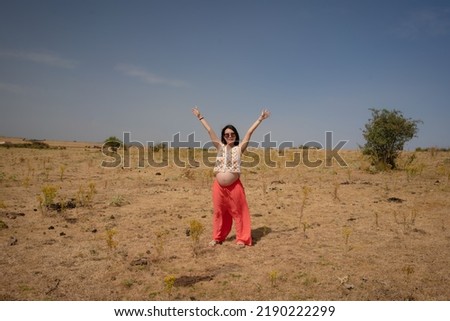 outdoors lifestyle portrait of young happy and beautiful Chinese woman enjoying summer holiday while pregnant proud of her belly as mother expecting baby concept