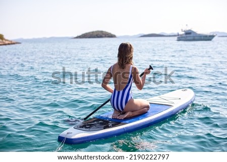 Woman Doing Watersports, Paddleboarding at Open Sea
