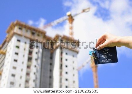 Mortgage. hand holds the key and the passport of an Israeli TRANSLATION: Teudat zehut the passport of a citizen. purchase of real estate on credit, from the developer, real estate agency. apartment 