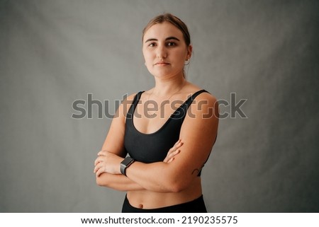 Focused Caucasian female standing crossed arms in the studio