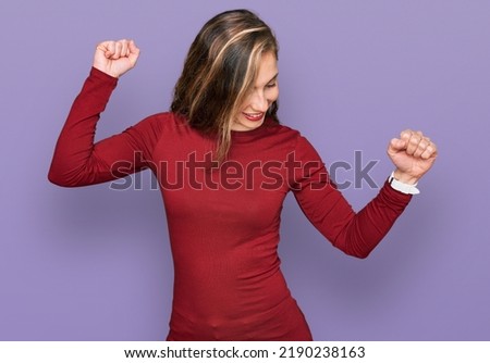 Young blonde woman wearing casual clothes dancing happy and cheerful, smiling moving casual and confident listening to music 