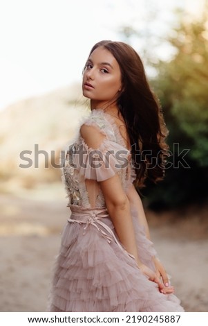 Fashionable young model in boho style dress on a background of rocks. Female beauty and style concept. Advertisement or clothes sale design.