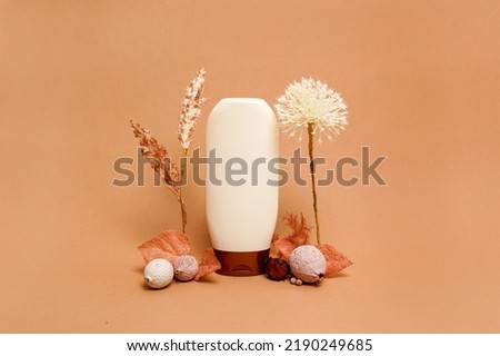 Beauty cosmetic bottle and dry autumn leaf creative still life cosmetic photography, orange background with copy space