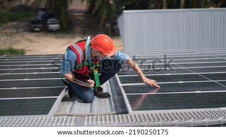 Engineers, males and females inspecting solar panels on the roof, inspecting safety and cleaning services. Construction industry, construction personnel