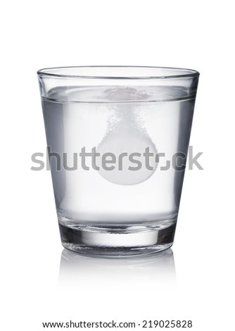 Glass with effervescent tablet in water with bubbles on white  background