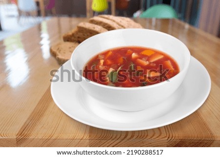Bowl with tasty soup on wooden background