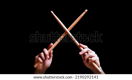 male drummer hands holding drumsticks in x shape. isolated on black Royalty-Free Stock Photo #2190292141