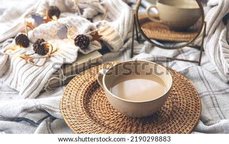 Cozy autumn composition with a big cup of coffee in bed.