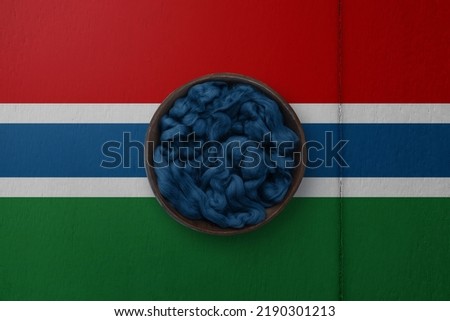 Wooden basket on background in colors of national flag. Photography and marketing digital backdrop. Gambia