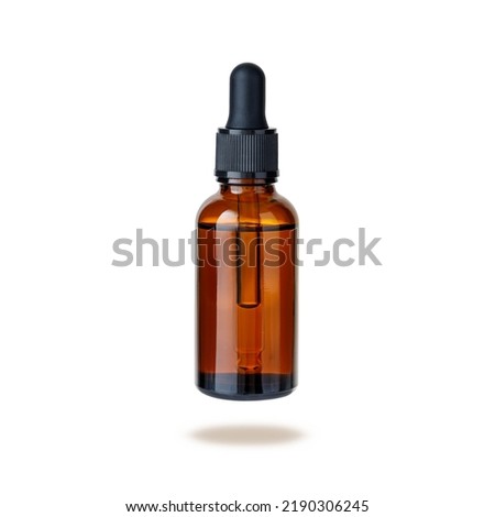 Dark brown amber glass bottle of face serum or essential oil or pharmaceutical tincture flying isolated on white background Royalty-Free Stock Photo #2190306245