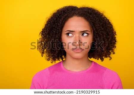 Photo of sad brunette young lady look empty space wear pink t-shirt isolated on vivid orange color background