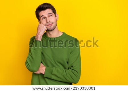 Photo of attractive dreamy guy dressed green pullover arm fist cheek looking empty space isolated yellow color background Royalty-Free Stock Photo #2190330301