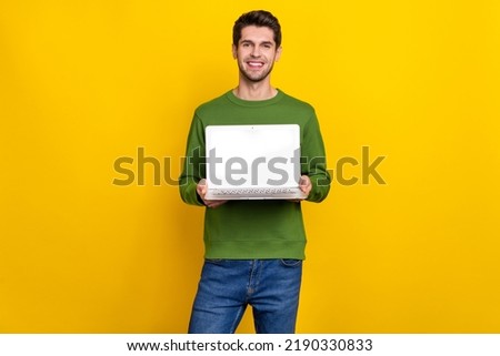 Photo of pretty attractive young guy dressed green pullover rising modern device empty space isolated yellow color background