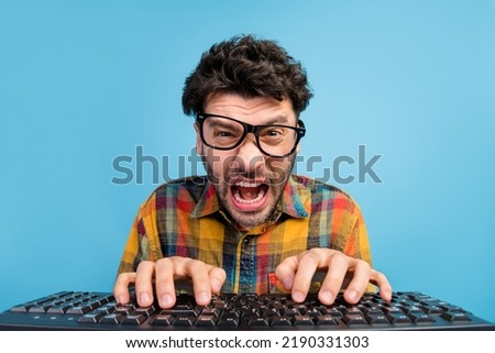 Photo of angry brunet guy type keyboard wear eyewear checkered shirt isolated on blue color background Royalty-Free Stock Photo #2190331303