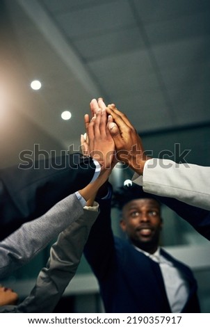 High five, teamwork and working together with a team or group of colleagues standing together in their corporate office. Motivation, success and achievement through unity, solidarity and trust Royalty-Free Stock Photo #2190357917