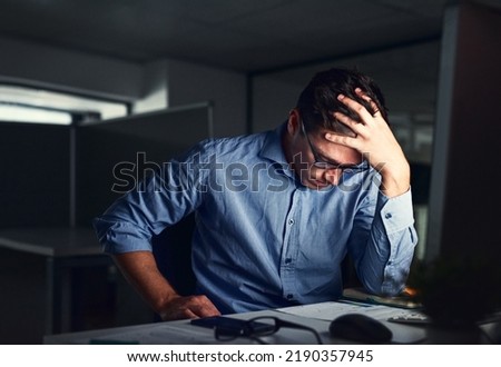 Stressed, tired business man suffering from headache, working late night in the office. Worried male entrepreneur thinking about problems and project deadline feeling burnout, distress and exhausted Royalty-Free Stock Photo #2190357945