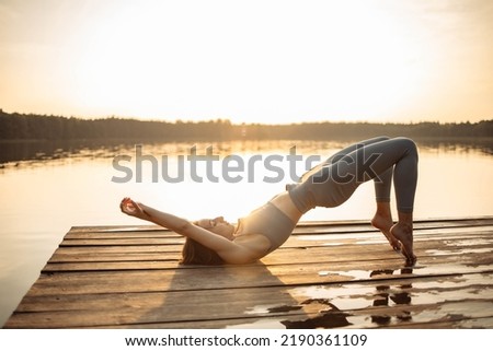 A girl does yoga at sunset