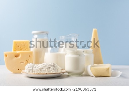 Variety of dairy products on blue background. Jug of milk, cheese, butter, yogurt or sour cream, cottage cheese. Farm dairy products concept Royalty-Free Stock Photo #2190363571