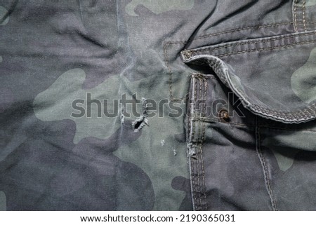 Uniform damaged. A hole in the camouflage fabric