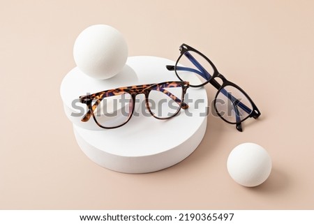 Stylish eyeglasses over pastel background. Optical store, glasses selection, eye test, vision examination at optician, fashion accessories concept. Top view, flat lay Royalty-Free Stock Photo #2190365497