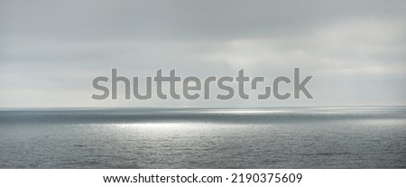 Panoramic view of the Baltic sea during the storm. Dramatic sky, sun rays through the dark clouds. Epic seascape. Finland. Concept image, ecology, meteorology, weather. Black and white, silver colors Royalty-Free Stock Photo #2190375609