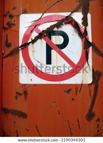 a no parking sign on a metal wall