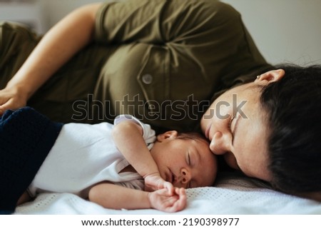 A mother and new born baby taking a nap together Royalty-Free Stock Photo #2190398977