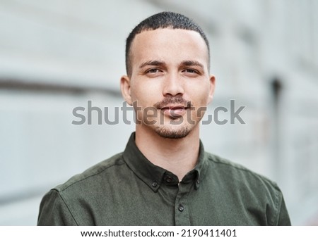 Closeup face of a serious, motivated and ambitious man standing outside in a city, town or downtown alone. Portrait, headshot and face of social worker or volunteer looking forward with trust or