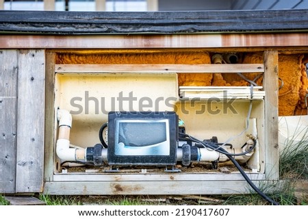 Side of hot tub with panel removed to repair and complete maintenance on the recirculation pump. Royalty-Free Stock Photo #2190417607