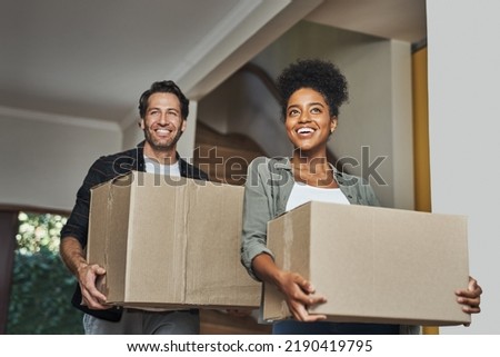 New house, moving and happy couple carrying boxes while feeling proud and excited about buying a house with a mortgage loan. Interracial husband and wife first time buyers unpacking in dream home Royalty-Free Stock Photo #2190419795