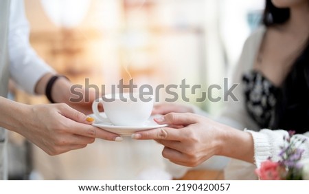 Closeup of woman barista serving cup of coffee to customer. Job and occupation. Food and drink beverage. Coffee shop and Cafe. Business and restaurant ownership Royalty-Free Stock Photo #2190420057