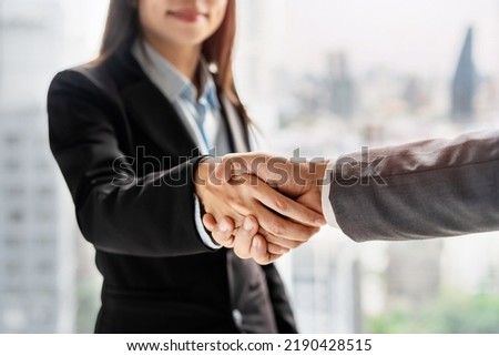 Businessman and businesswoman shaking hands, Partnership Successful deal after meeting with skyscrapers background, Business cooperation concept Royalty-Free Stock Photo #2190428515