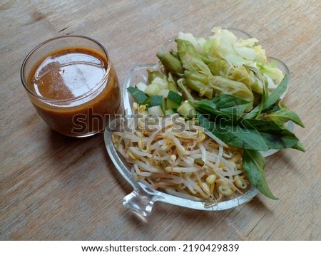 Pecel. In the form of several vegetables in the form of cabbage, sprouts, cucumber, turi flower and basil mixed with peanut sauce. Boiled vegetables are placed on a plate. Indonesian food.