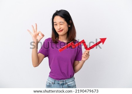 Young Vietnamese woman isolated on white background holding a catching a rising arrow and doing OK sign