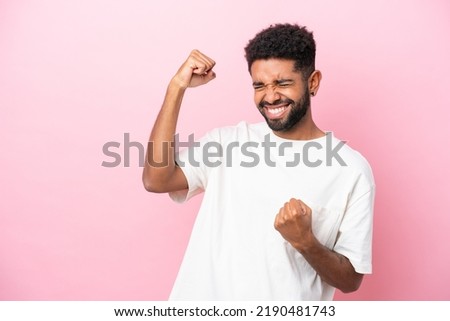 Young Brazilian man isolated on pink background celebrating a victory Royalty-Free Stock Photo #2190481743