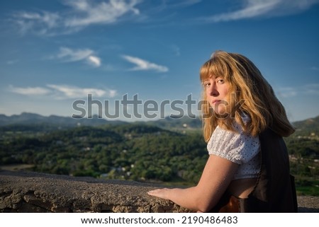 blonde girl at the gazebo in front of the forest