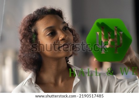 Portrait of African American entrepreneur applying sticker with her new company name onto a glass door of the office