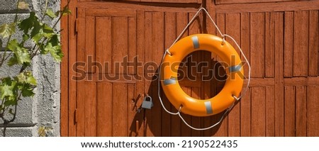 Bright lifebuoy ring hanging on gates