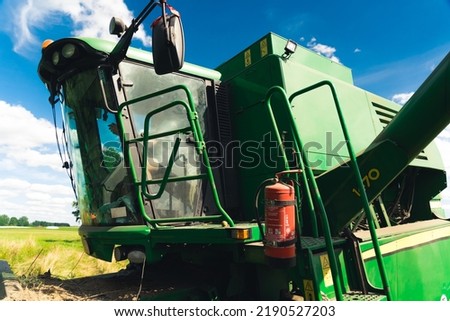 combine harvester picking up rapeseed on a sunny day, good prosperity concept. High quality photo