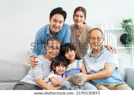Portrait of Asian loving family and kid daughter stroking cat in house. Happy family, Attractive happy multi generation sitting on sofa spendind free leisure time together with their pet at home. Royalty-Free Stock Photo #2190530893